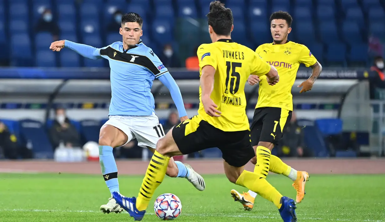 Penyerang Lazio, Joaquin Correa (kiri) berebut bola dengan bek Borussia Dortmund, Mats Hummels pada pertandingan perdana Grup F Liga Champions 2020 di Stadion Olimpico, Rabu (21/10/2020) dini hari WIB. Lazio menang 3-1 atas Borussia Dortmund. (Alberto PIZZOLI / AFP)