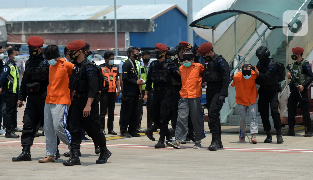 Anggota Densus 88 Antiteror menggiring terduga teroris saat tiba di Bandara Soekarno-Hatta, Tangerang, Banten, Kamis (18/3/2021). Polri memindahkan 22 terduga teroris jaringan kelompok Jamaah Islamiyah (JI) dari Jawa Timur ke Jakarta. (merdeka.com/Imam Buhori)