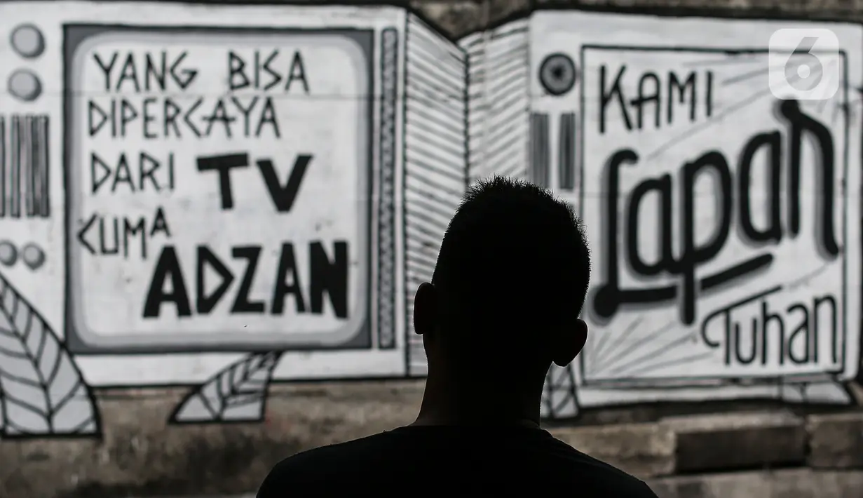Mural yang bertuliskan “Kami Lapar Tuhan” di kawasan Jakarta Pusat, Selasa (24/8/2021). Banyak beberapa tempat mural yang menyuarakan kebebasan berpendapat saat ini menjadi viral lantaran dihapus oleh petugas. (Liputan6.com/Johan Tallo)