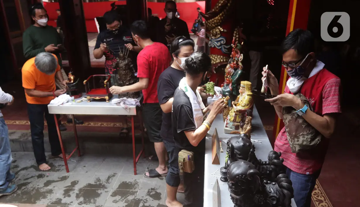 Warga keturunan Tionghoa melaksanakan tradisi membersihkan patung dewa-dewi atau rupang di Vihara Dhanagun, Kota Bogor, Rabu (27/1/2022). Kegiatan membersihkan patung dewa dewi sebagai persiapan menyambut Tahun Baru Imlek 2753 pada Selasa, 1 Februari mendatang. (Liputan6.com/Helmi Fithriansyah)