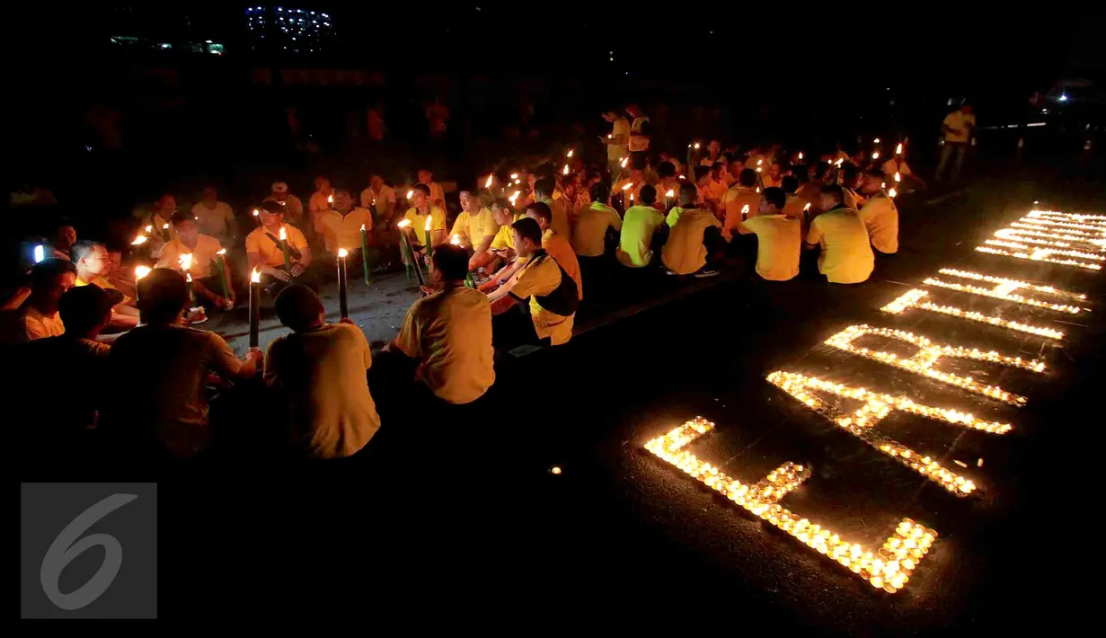 Puluhan karyawan Artha Graha Peduli menyalakan lilin saat menggelar Earth Hours di kawasan SCBD Jakarta, Sabtu (25/3). Kegiatan ini mendukung kampanye perubahan iklim dan pencegahan pemanasan global dengan pemadaman listrik. (Liputan6.com/Fery Pradolo)