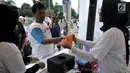 Warga menerima handuk setelah menukarkan tiga botol plastik bekas di stan ENVIRUN selama hari bebas kendaraan atau car free day (CFD) di Jakarta, Minggu (8/4). (Merdeka.com/Iqbal Nugroho)