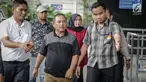 Asisten III Pemprov Jambi Syaifuddin (tengah), Anggota DPRD Jambi Nurhayati (belakang) dikawal petugas memasuki Gedung KPK, Jakarta, Rabu (29/11). KPK melakukan operasi tangkap tangan di Provinsi Jambi. (Liputan6.com/Faizal Fanani)