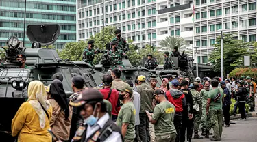 Tentara berdiri di atas alat utama sistem senjata (alutsista) saat perayaan HUT ke-77 TNI di Bundaran HI, Jakarta, Rabu (5/10/2022). Kegiatan yang diikuti oleh seluruh kesatuan jajaran TNI ini dalam rangka menyambut HUT ke-77 TNI. (Liputan6.com/Faizal Fanani)