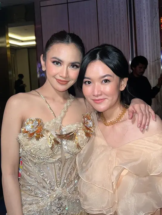 Gaun tersebut pun memiliki aksen cross neck pada bagian atas. Lalu detail bunga besar warna keemasan. Gaun tersebut pun tampak mewah dengan payet silver keemasan. [@vinaavaniaa]