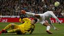 Pemain Real Madrid, Cristiano Ronaldo, berebut bola dengan kiper Sevilla, Sergio Rico, pada laga La Liga Spanyol di Stadion Santiago Bernabeu, Madrid, Minggu (20/3/2016). Gol Madrid dicetak oleh Benzema, Ronaldo, Bale dan Jese. (Reuters/Sergio Perez)