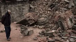 Seorang laki-laki melihat sisa bangunan yang runtuh akibat gempa berkekuatan 7,8  di sekitar Kathmandu, Nepal  (30/4/2015). Gempa berkekuatan 7,8 yang meluluhlantakkan Nepal pada 25 April 2015 lalu. (Nicolas Asfouri/AFP)