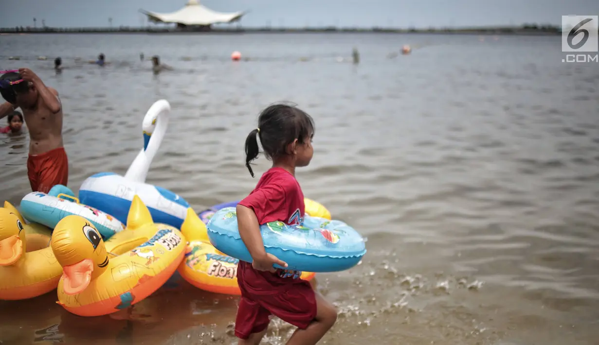 Seorang anak bersiap berenang di Beach Pool Ancol, Jakarta, Selasa (25/12). Pasangnya air laut dan cuaca buruk mengakibatkan pantai Ancol sepi pengunjung saat libur Natal 2018. (Liputan6.com/Faizal Fanani)