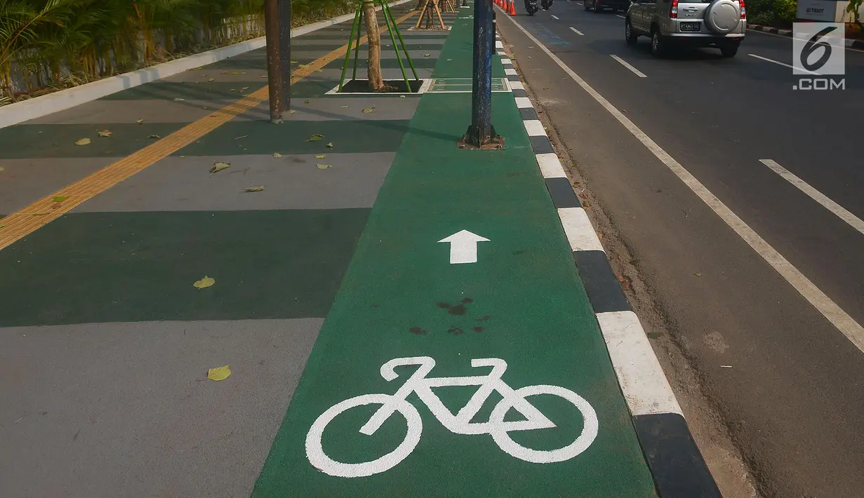 Penampakan jalur sepeda di kawasan Gelora Bung Karno (GBK), Jalan Asia Afrika, Jakarta, Selasa (31/7). Jalur sepeda ini terhalang tiang listrik, penerangan jalan umum (PJU), lampu lalu lintas, hingga rambu penunjuk jalan. (Merdeka.com/Imam Buhori)