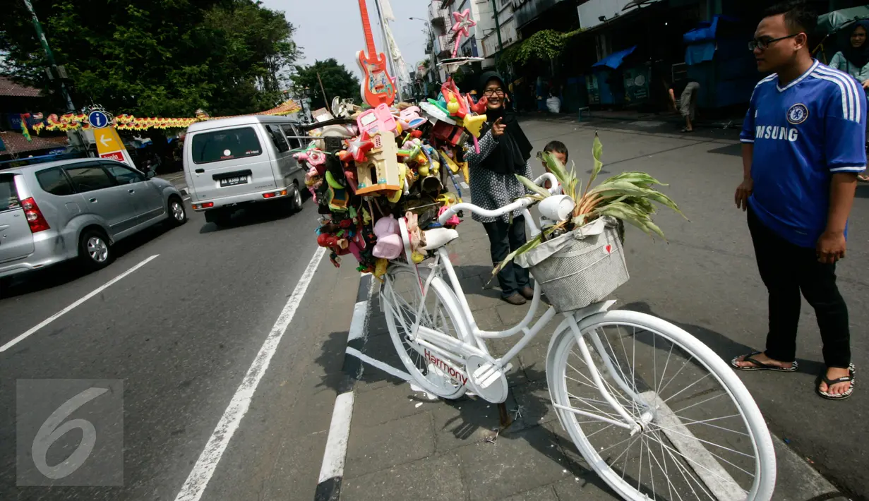Pengunjung menyaksikan karya instalasi sepeda onthel yang menghiasi Jl.Malioboro, Yogyakarta, (5/6). Sepanjang jalanan Malioboro sering dihiasi instalasi-instalasi seni karena merupakan tempak yang banyak dikunjungi wisatawan. (Boy Harjanto)