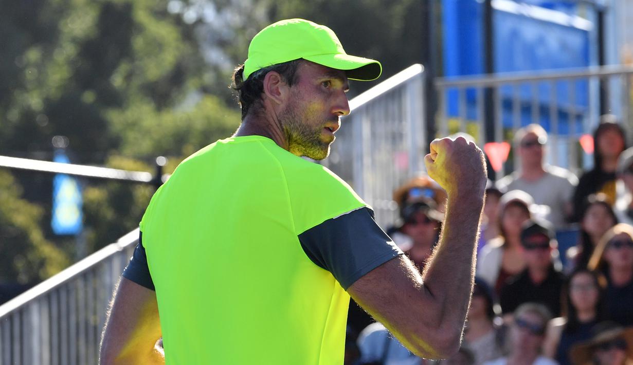 Petenis Kroasia, Ivo Karlovic berselebrasi setelah mengalahkan Yuichi Sugita (Jepang) di babak kedua Australia Terbuka 2018, Rabu (17/1). Durasi pertandingan Karlovic dan Yuichi menjadi rekor terpanjang di turnamen ini, 4 jam dan 33 menit (SAEED KHAN/AFP)