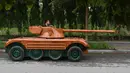 Truong Van Dao duduk tank kayu di daerah perumahan di provinsi Bac Ninh, Vietnam pada 28 Maret 2022. Kendaraan kayu, berdasarkan model EBR105 Prancis dan lengkap dengan meriam replika sepanjang 2,8 meter itu, menghabiskan dana USD11 ribu atau sekitar Rp158 juta. (Nhac NGUYEN /AFP)
