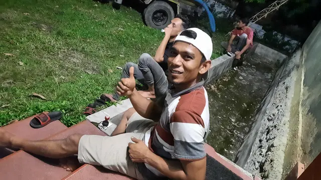 Marzuki (34), pemilik mobil tangki penyedot tinja, ketika sedang mengaso di rumah pelanggan (Liputan6.com/Rino Abonita)