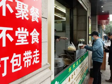 Para pelanggan mengantre untuk membeli mi sapi di sebuah restoran di Xiangyang, Provinsi Hubei, China tengah, pada 16 Maret 2020. Beberapa restoran mi sapi di Xiangyang kembali melanjutkan bisnis dengan layanan take away pada Senin (16/3). (Xinhua/Xie Jianfei)