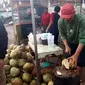 Salah seorang pedagang kelapa muda di bilangan jalan Tarogong Garut, nampak terampil mengupas dan membelah kelapa muda pesanan pembeli menjela buka puasa Ramadan (Liputan6.com/Jayadi Supriadin)