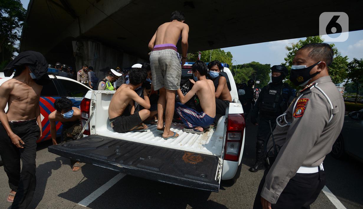 Sejumlah orang menaiki mobil polisi setelah diamankan di Kawasan Senayan, Jakarta, Kamis (8/10/2020). Mereka diduga hendak melakukan unjuk rasa di depan gedung DPR. (merdeka.com/Imam Buhori)