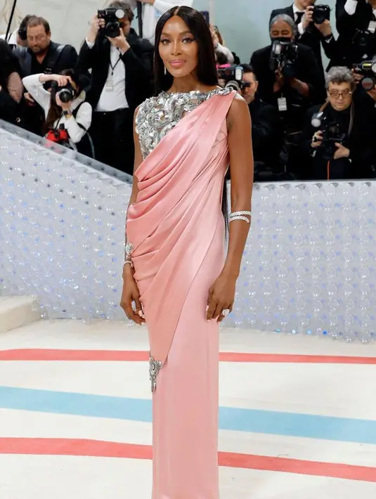 Naomi Campbell tampak cantik dalam balutan gaun Chanel pink muda. Dan wajah bercahaya dalam riasan Pat McGrath. [@themetgalaofficial]