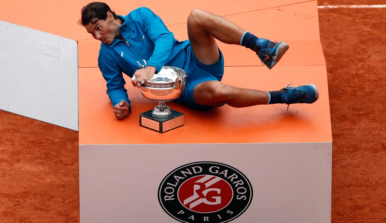 Petenis Spanyol, Rafael Nadal berpose dengan pialanya setelah mengalahkan Dominic Thien dari Austria pada partai final Prancis Terbuka di Roland Garros, Minggu (10/6). Nadal merebut gelar juara Prancis Terbuka untuk kali ke-11. (AP/Christophe Ena)