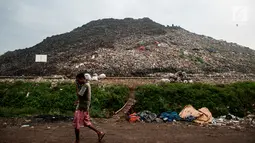 Seorang warga melintas di depan tumpukan sampah di TPA Bantar Gebang, Kota Bekasi, Jawa Barat.  (Liputan6.com/Yoppy Renato)