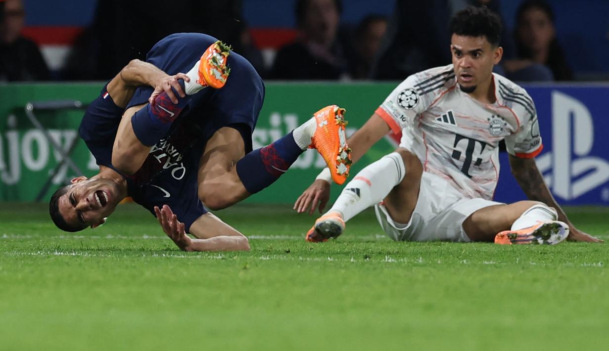 Pemain PSG, Achraf Hakimi (kiri) mengeram kesakitan setelah dijegal pemain Bayern Munchen, Luis Diaz dalam laga Liga Champions 2025/2026 di Parc des Princes, Paris, Prancis, Selasa (04/11/2025) waktu setempat. (AFP/Franck Fife)