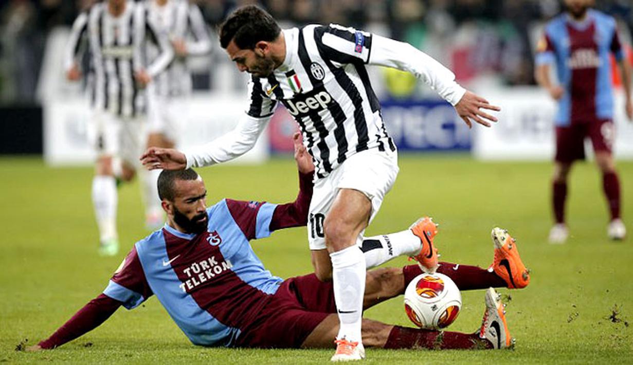 Carlos Tevez berjuang mempertahankan bola dari Jose Bosingwa pada putaran leg pertama 32 besar Liga Eropa antara Juventus vs Trabzonspor di stadion Juventus, Turin pada 21 Februari 2014 (AFP/Marco Bertorello).