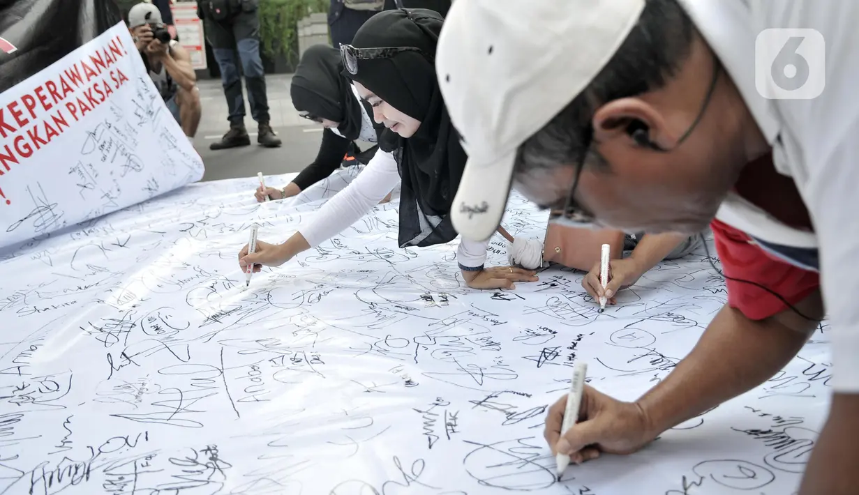 Warga membubuhkan tanda tangan sebagai bentuk dukungan untuk atlet senam SA (17), Jalan MH Thamrin, Jakarta, Minggu (8/12/2019). Massa menuntut pelatih yang memulangkan SA dari SEA Games Filipina meminta maaf dan negara melakukan pemulihan terhadap nama korban. (merdeka.com/Iqbal Nugroho)