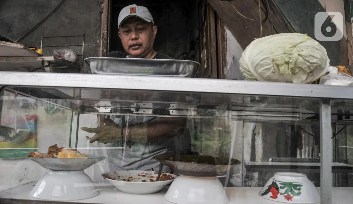 Pedagang saat melayani pembeli di salah satu warung kerek di Kuningan Barat, Mampang Prapatan, Jakarta Selatan, Rabu (25/5/2022). Seperti diketahui, terdapat enam warung kerek di kawasan tersebut yang berdiri sejak 2014 saat jembatan penghubung dua wilayah itu dihancurkan bersamaan proyek pengerukan kali. (merdeka.com/Iqbal S Nugroho)
