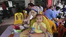 Pengunjung makan di restoran, Karachi, Pakistan, Senin (10/8/2020). Pakistan mengurangi pembatasan terkait COVID-19 menyusul tingkat kasus harian tetap di bawah 1.000 selama lebih dari empat minggu. (AP Photo/Fareed Khan)