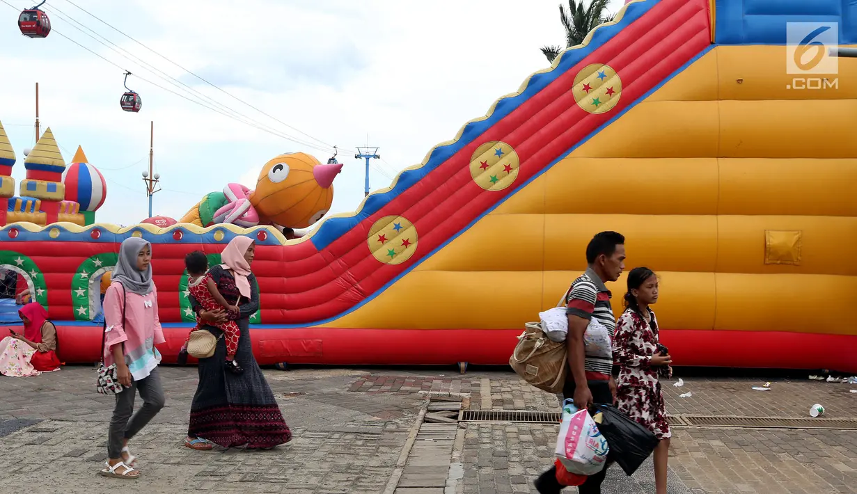 Pengunjung berlibur di Pantai Ancol, Jakarta, Senin (26/6). Memasuki hari kedua lebaran Warga memanfaatkan liburnya bersama keluarga bertamasya ke tempat-tempat wisata yang ada di Jakarta kususnya Ancol. (Liputan6.com/Johan Tallo)