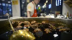 Koki menyiapkan menu kepala kelinci di sebuah restoran di Chengdu, ibu kota Provinsi Sichuan di barat daya China, 8 September 2016. Otak kelinci di negeri tirai bambu ini menjadi salah satu menu favorit warga lokal maupun asing. (WANG ZHAO/AFP)