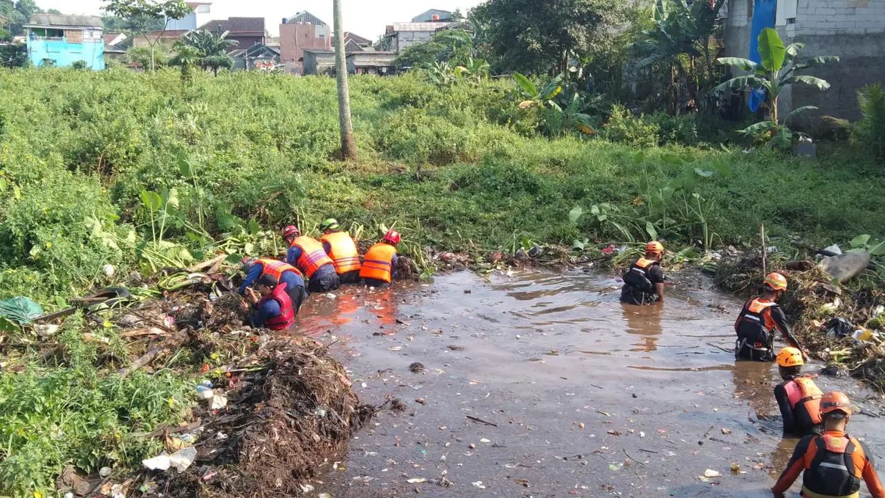 Petugas DPKP Kota Depok bersama tim pencarian gabungan menemukan korban hilang terbawa arus banjir di Kecamatan Pancoran Mas, Kota Depok. (