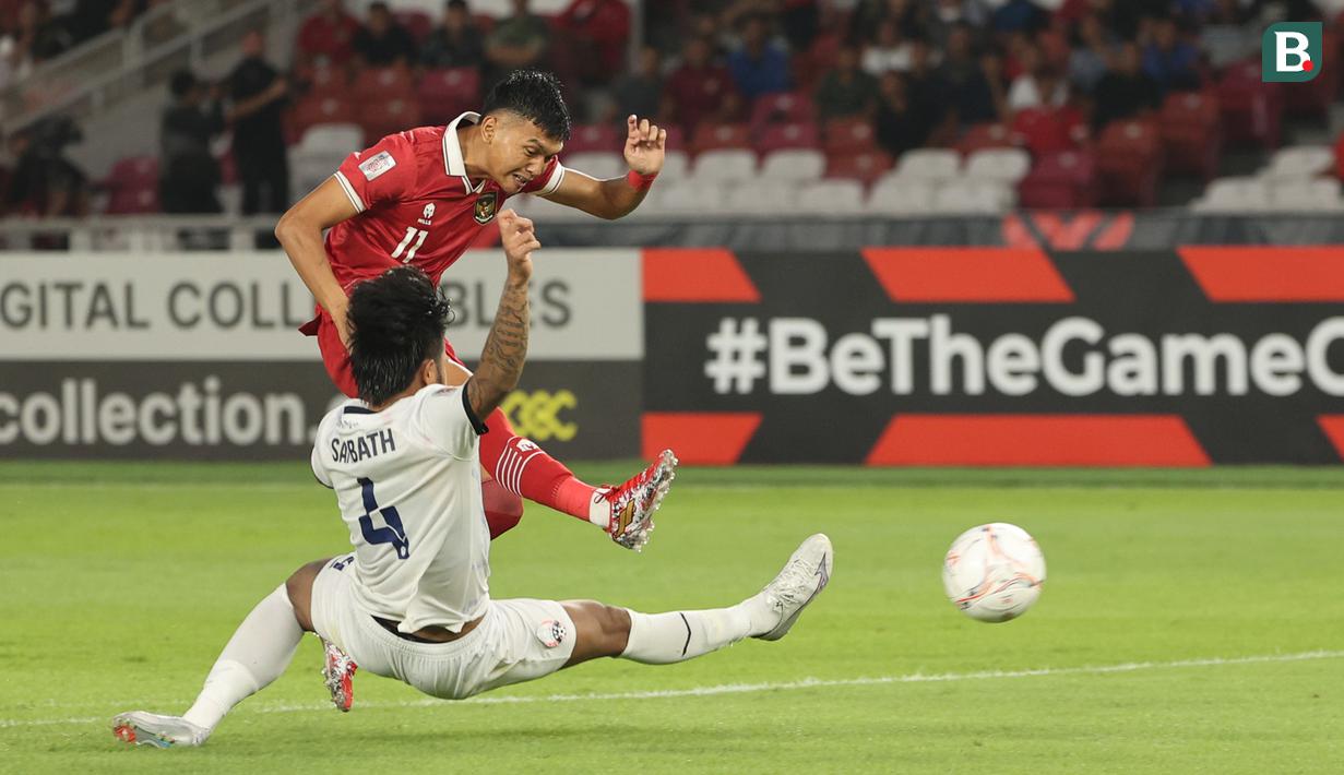 <p>Pemain Timnas Kamboja, Tes Sambath (kanan) berusaha menghadang tendangan pemain Timnas Indonesia, Dendy Sulistyawan dalam laga Grup A Piala AFF 2022 yang berlangsung di Stadion Utama Gelora Bung Karno, (SUGBK), Jumat (23/12/2022). (Bola.com/Abdul Azis)</p>
