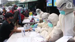 Warga mengikuti Rapid Test Covid-19 yang dilakukan oleh dinkes Provinsi Banten di Pasar Anyar, Tangerang, Selasa (21/4/2020). Warga dapat melakukan isolasi mandiri setelah mengetahui hasil dari Rapid Test Covid-19 tersebut. (Liputan6.com/Angga Yuniar)