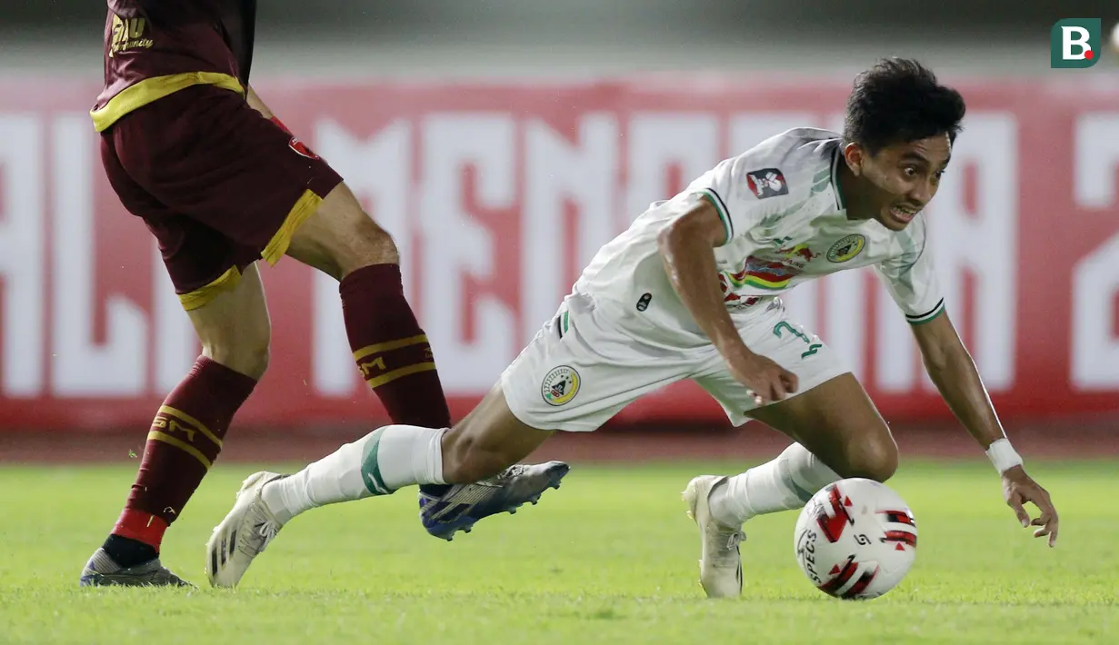 Pemain PS Sleman, Fitrah Ridwan, terjatuh saat berebut bola dengan pemain PSM Makassar pada laga perebutan juara tiga Piala Menpora 2021 di Stadion Manahan, Solo, Sabtu (24/4/2021). (Bola.com/M Iqbal Ichsan)