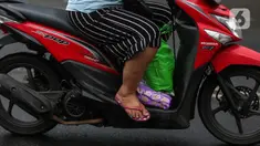 Warga menggunakan sepeda motor melintasi jalan Bintaro Permai, Jakarta, Rabu (15/6/2022). Korps Lalu Lintas (Korlantas) Polri menghimbau kepada masyarakat khususnya pengguna motor untuk tidak menggunakan sandal dan celana pendek saat berkendara dikarenakan,sandal jepit tidak akan melindungi bagian kaki pengendara. (Liputan6.com/Johan Tallo)
