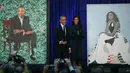 Presiden AS ke-44 Barack Obama bersama istrinya Michelle Obama berdiri di samping lukisan mereka berdua saat upacara peresmian di Galeri Potret Nasional Smithsonian, Washington DC (12/2). (Mark Wilson/Getty Images/AFP)