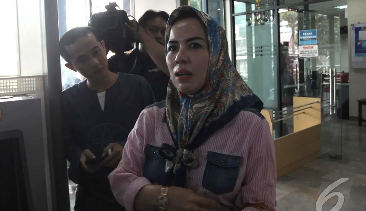 Lia Tri Tirta Sari, istri Muhtar Ependy (orang dekat mantan Ketua Mahkamah Konstitusi Akil Mochtar) tersenyum di Gedung KPK, Jakarta, Jumat (24/10/2014) (Liputan6.com/Johan Tallo)