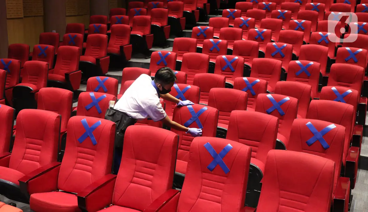 Petugas memasang tanda menjaga jarak di kursi di Perpustakaan Nasional, Jakarta, Kamis (10/6/2020). Perpusnas membuka kembali membuka pelayanan mulai Kamis ini, 11 Juni 2020, dengan menyiapkan protokol kesehatan setelah beberapa bulan tutup akibat COVID-19. (Liputan6.com/Angga Yuniar)