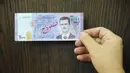Seseorang menunjukkan uang kertas saat konferensi pers Gubernur Bank Sentral Suriah di Damaskus, Suriah, 2 Juli 2017. Sepanjang 2019, Pound Suriah telah kehilangan lebih dari 80 persen nilainya di tengah sanksi ekonomi dari AS dan Eropa serta pengaruh krisis keuangan di Lebanon. (SANA via AP, File)