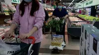 Orang-orang membeli makanan dan kebutuhan rumah tangga di sebuah supermarket di Beijing pada 25 April 2022. Kekhawatiran penguncian Covid memicu pembelian panik dan antrean panjang untuk pengujian massal di Beijing pada 25 April ketika otoritas China bergegas untuk membasmi wabah di ibu kota. (AFP/Noel Celis)