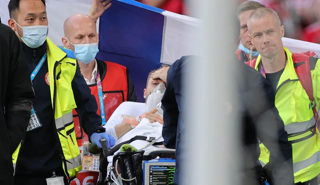Menurut laporan Kicker, Tim Dokter kabarnya mengangkat jempol ke atas sebelum Eriksen dibawa keluar. Tanda jempol ke atas ini mengindikasikan kondisi Eriksen sudah baikan, dan itu sudah disambut sorakan penonton diatas lapangan. (Foto: AFP/Pool/Friedemann Vogel)