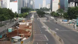 Sejumlah kendaraan melintas di Jalan Thamrin, Jakarta, Jumat (15/6). Pada Hari Raya Lebaran hari pertama, sejumlah ruas jalan di Jakarta tampak sepi dan lengang, berbeda dengan kondisi normal yang padat dan macet. (Liputan6.com/Arya Manggala)