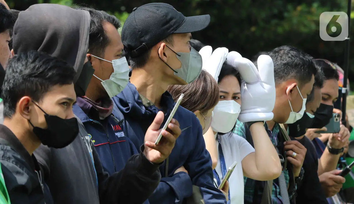 Warga berkumpul untuk menyaksikan parade pembalap MotoGP di kawasan Jakarta, Rabu (16/3/2022).  Gelaran parade MotoGP di Jakarta dalam rangka penyambutan event MotoGP Mandalika 2022. (Liputan6.com/Herman Zakharia)