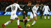 Bek Manchester City, Kevin De Bruyne menggiring bola dengan kawalan pemain Swansea City pada lanjutan Premier League di Liberty Stadium, Rabu (13/12). Man City mencatatkan rekor 15 kemenangan berturut-turut usai menang 4-0. (GEOFF CADDICK / AFP)