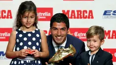 Penyerang Barcelona, Luis Suarez bersama kedua anaknya Delfina dan Benjamin, berpose dengan trofi Sepatu Emas Eropa 2016 selama penghargaan Golden Shoe atau sepatu emas untuk tahun 2016 di Barcelona, Spanyol (20/10). (REUTERS/Albert Gea)