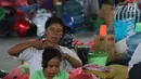 Seorang ibu dan anaknya beraktivitas di GOR Swecapura, Klungkung, Bali, Senin (27/11). Pada saat Gunung Agung ditetapkan status awas bulan September lalu, total pengungsi di Kabupaten Klungkung sempat mencapai 24 ribu jiwa. (Liputan6.com/Andi Jatmiko)