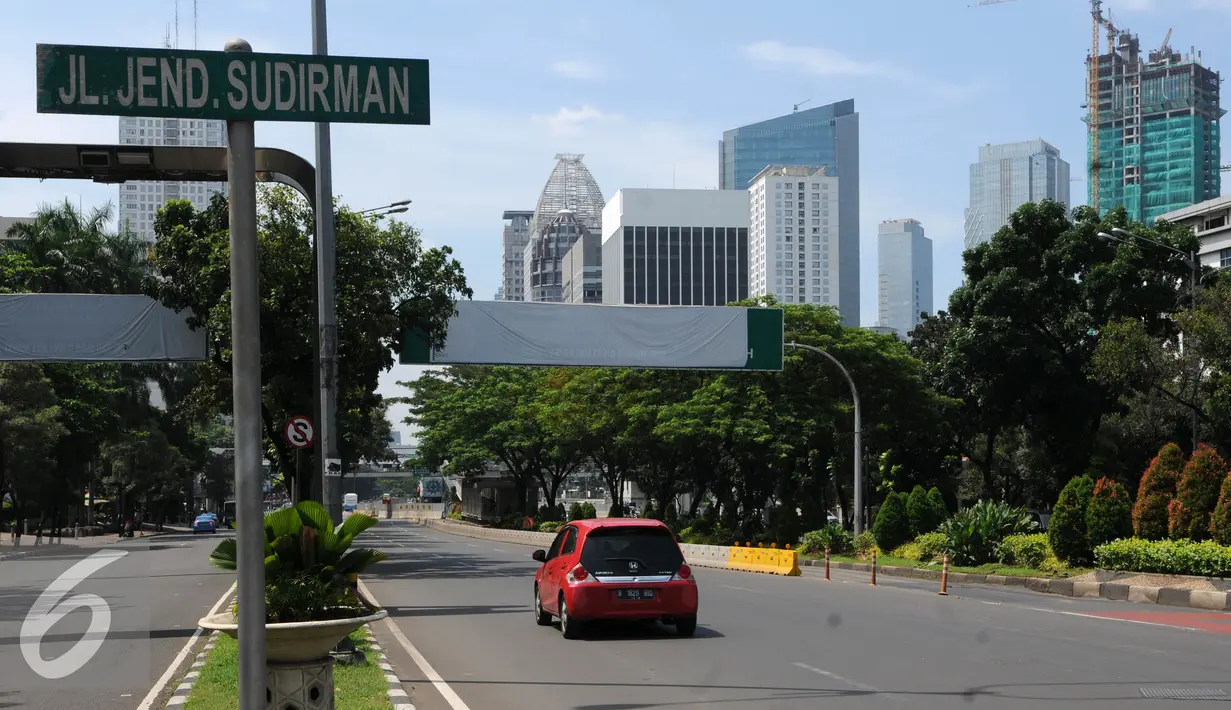 Kendaraan melintas di dekat Papan pemberitahuan Uji Coba jalur di Kawasan kuningan, Jakarta, Sabtu (23/7). Mulai 27 Juli sampai 26 Agustus Dishub Jakarta akan Uji Coba pembatasan Lalu Lintas Ganjil-Genap di Jalur Bekas 3 in 1. (Liputan6.com/Helmi Afandi)