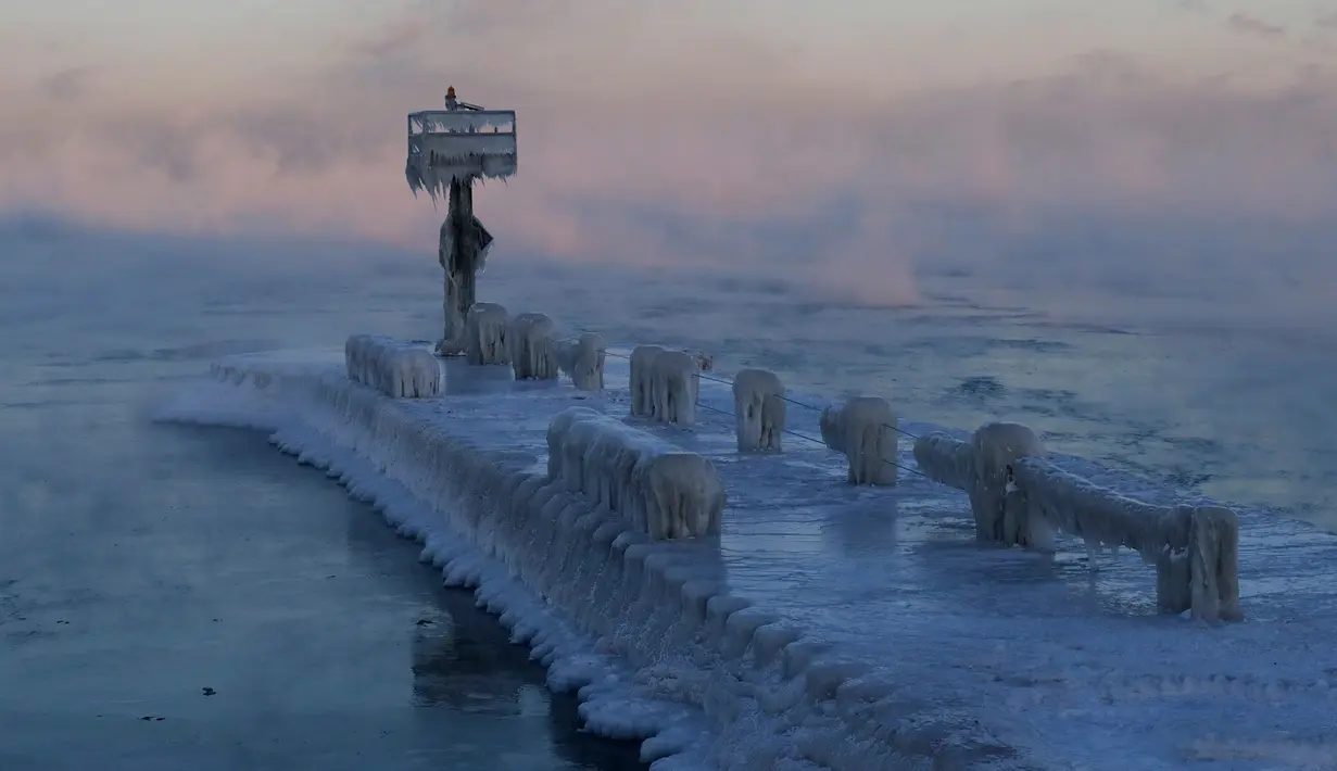 Sebuah lampu pelabuhan tertutup salju dan es di Danau Michigan di 39th Street Harbor, Chicago, Rabu (30/1). Cuaca dingin ekstrem yang terjadi sekali dalam satu generasi sedang melanda beberapa wilayah Amerika Serikat. (AP/Nam Y. Huh)