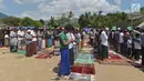 Umat muslim salat Jumat di sebuah ladang di dekat tempat penampungan sementara setelah gempa di Pemenang, Lombok (10/8). Menurut menteri senior, korban tewas akibat gempa dahsyat 6,9 SR di pulau Lombok melonjak di atas 300 orang. (AFP Photo/Adek Berry)