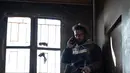 Anggota Syrian Democratic Forces (SDF) mengintai militan ISIS dari sebuah bangunan di kantong terakhir kekhalifahan di Baghouz, Suriah, Senin (18/2). ISIS menggunakan ribuan warga sipil sebagai perisai manusia. (AP Photo/Felipe Dana)